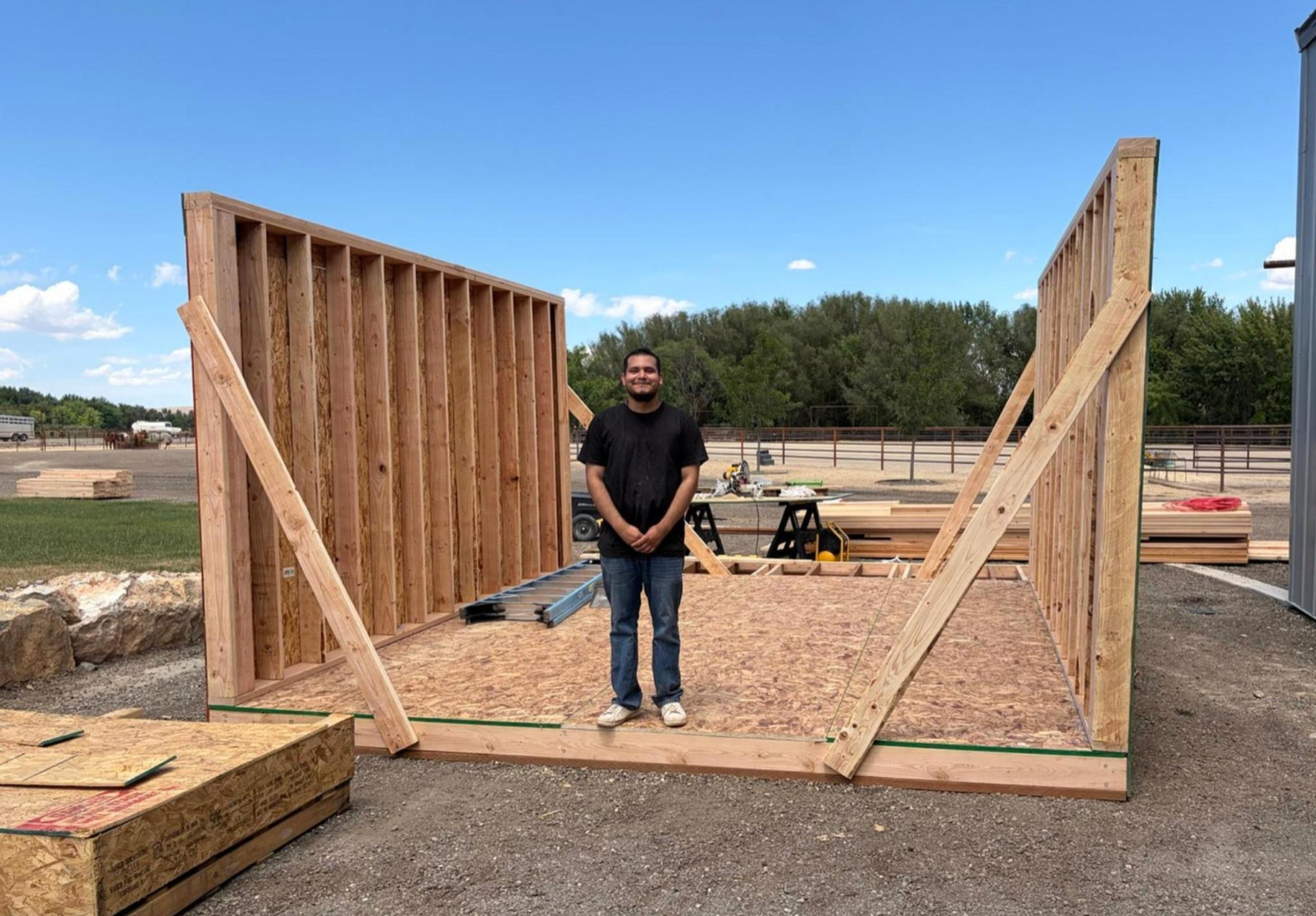 A fellow standing inside the frame of a small home under construction